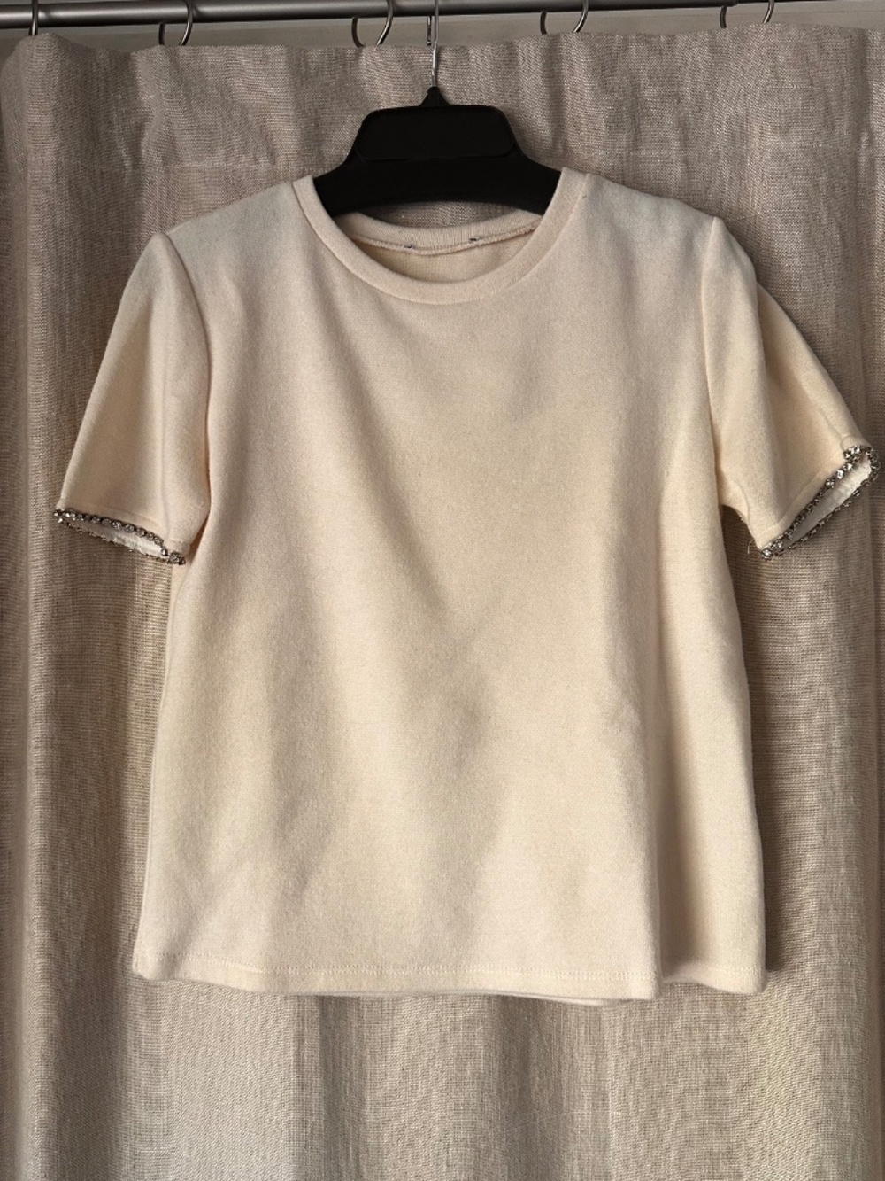 Sweet off white sweater with diamond detail around the sleeves.